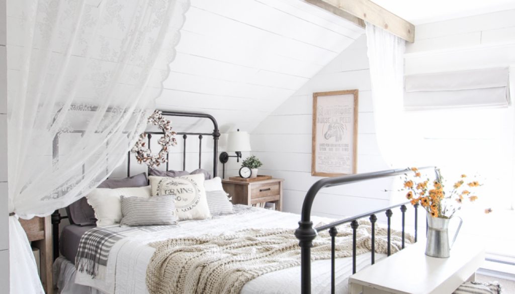 Minimalistic bedroom with white decor, featuring a sleek table, a stylish lamp, and a beautiful flowerpot designed by Woodmax, a top interior designer in Kasaragod, Kerala