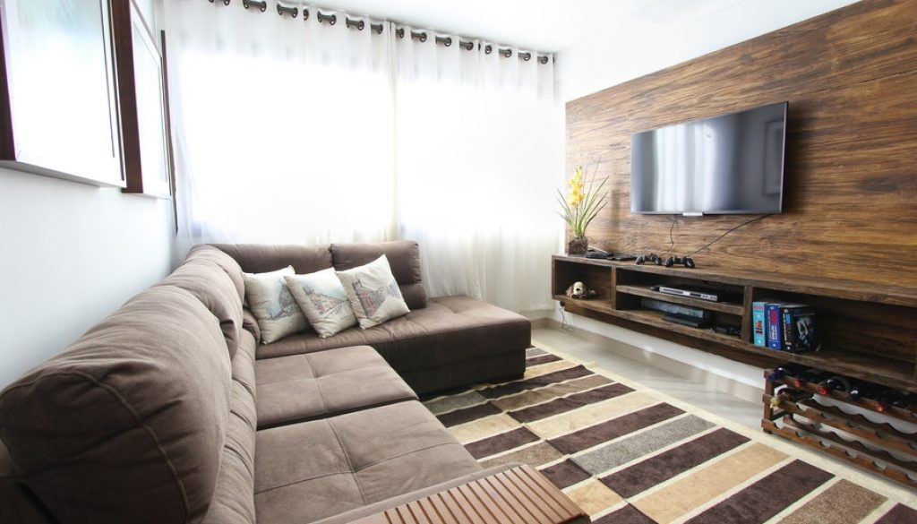 Interior design of a cozy living room featuring a comfortable sofa, stylish television, and wooden accents, created by Woodmax